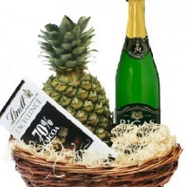 Pineapple, sparkling drink and chocolate in basket