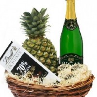 Pineapple, sparkling drink and chocolate in basket